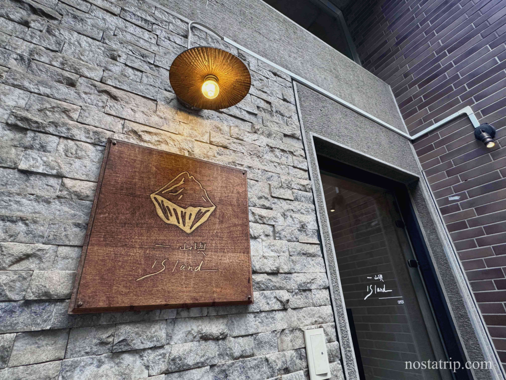 一嶼 Island 店面入口招牌與石牆質感特寫，搭配暖黃燈光