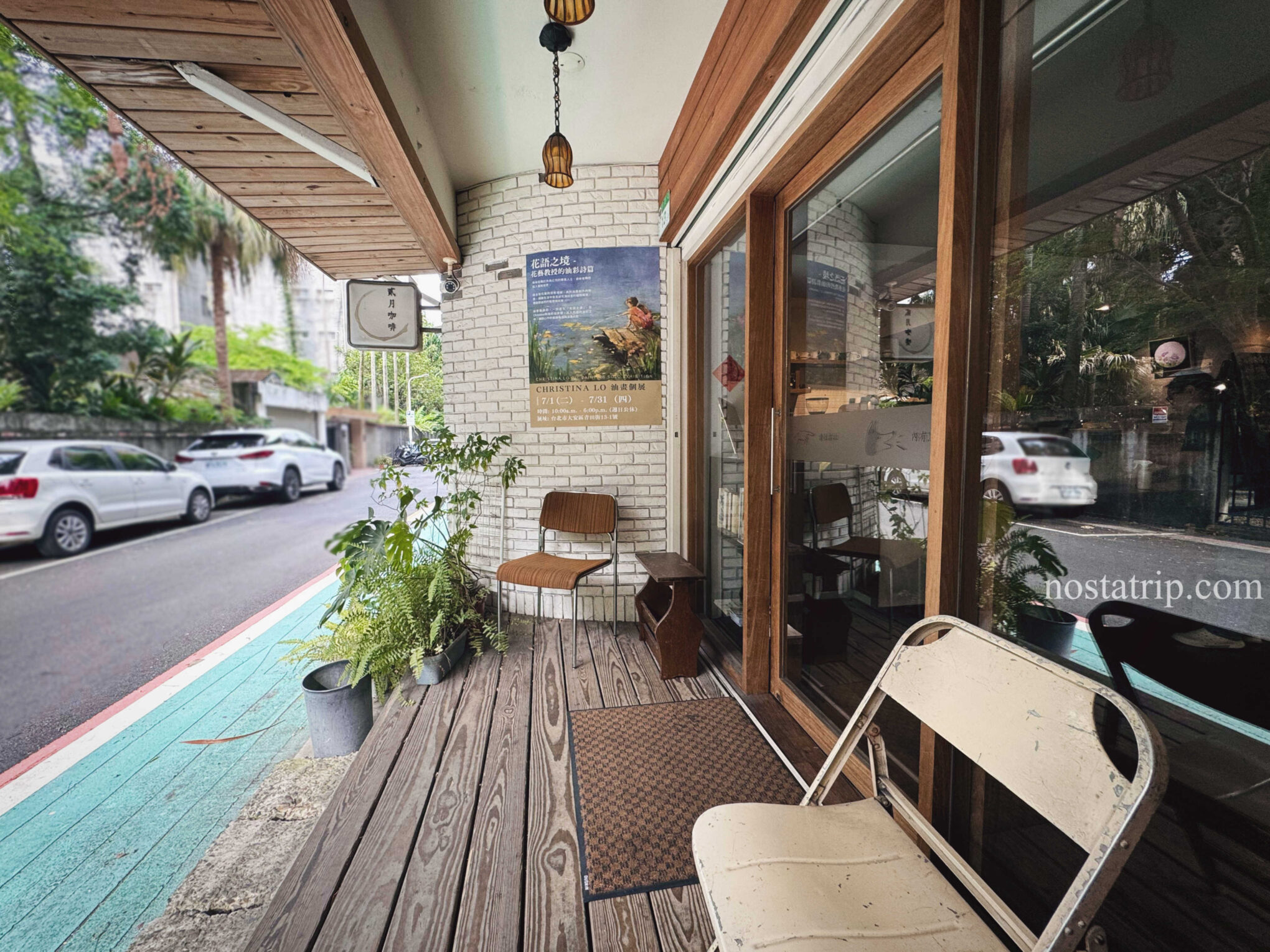 貳月咖啡門口街景，斑駁老椅與木地板構成靜謐氛圍，展現青田街懷舊街角。