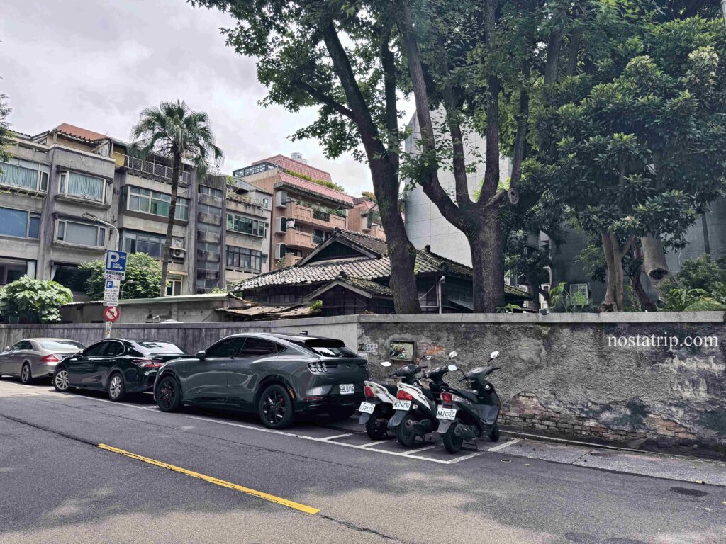 青田街老宅與街景全貌，牆邊老樹與現代建築共存