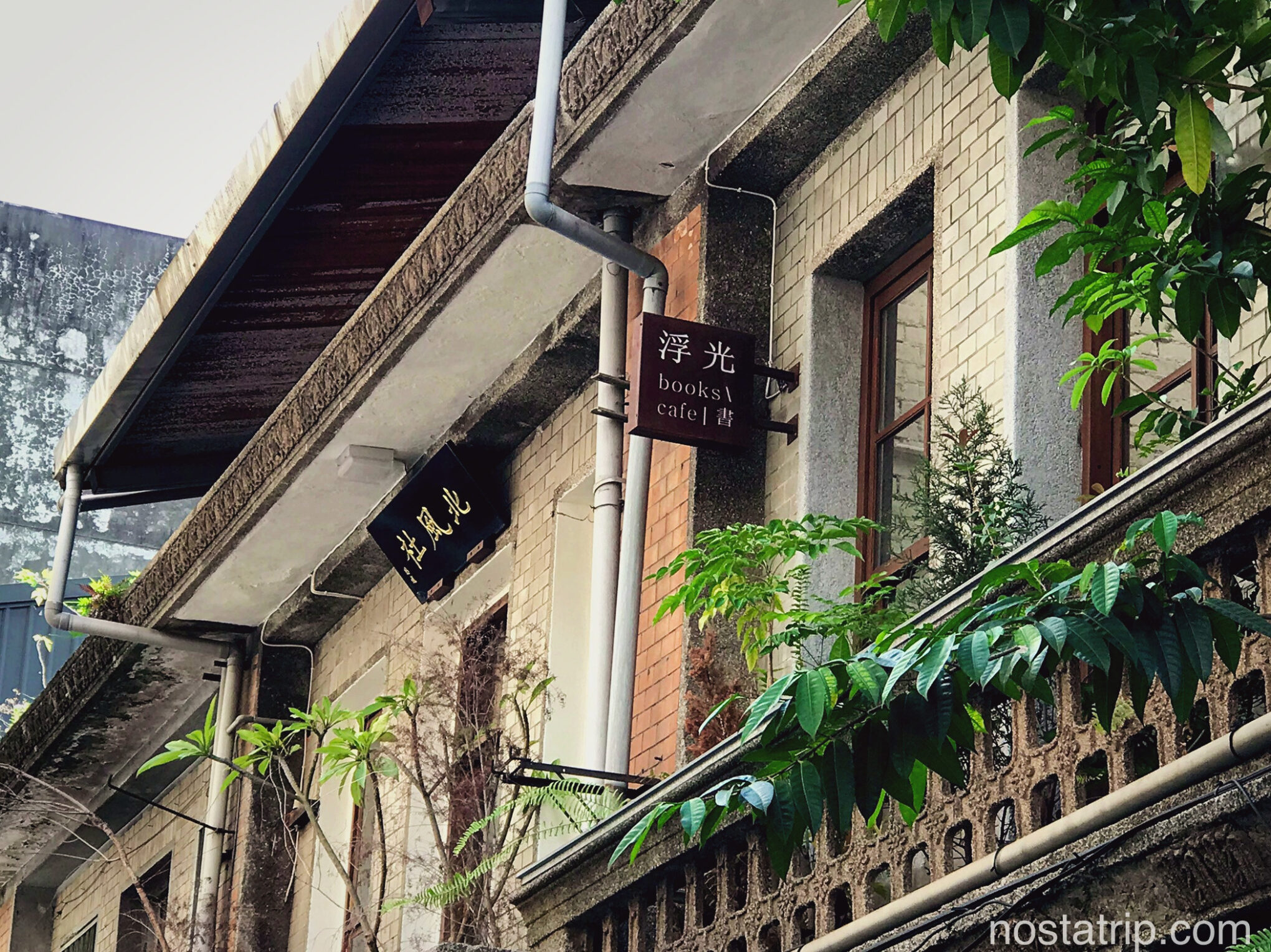 赤峰街的浮光書店外觀,老屋二樓的招牌在綠意間閃著光,靜靜訴說街角的故事。