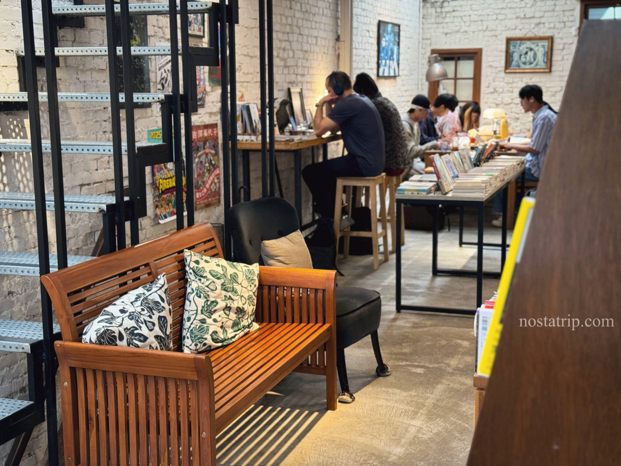浮光書店內的長桌與木椅座位區,人們靜靜閱讀與書寫。
