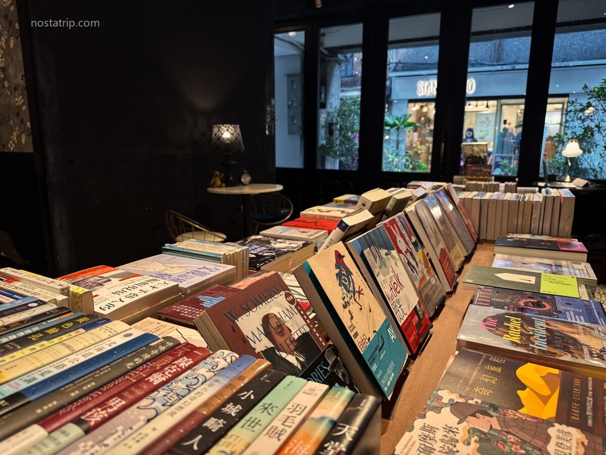 赤峰街春秋書店內的書籍展示桌，多本書籍面向讀者陳列，後方是黑色窗框與窗邊座位。